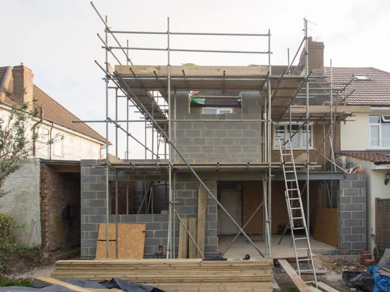 Chantier de maçonnerie : extension de maison en gros œuvre avec échafaudage